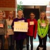 6 girl scouts holding a sign with nametags